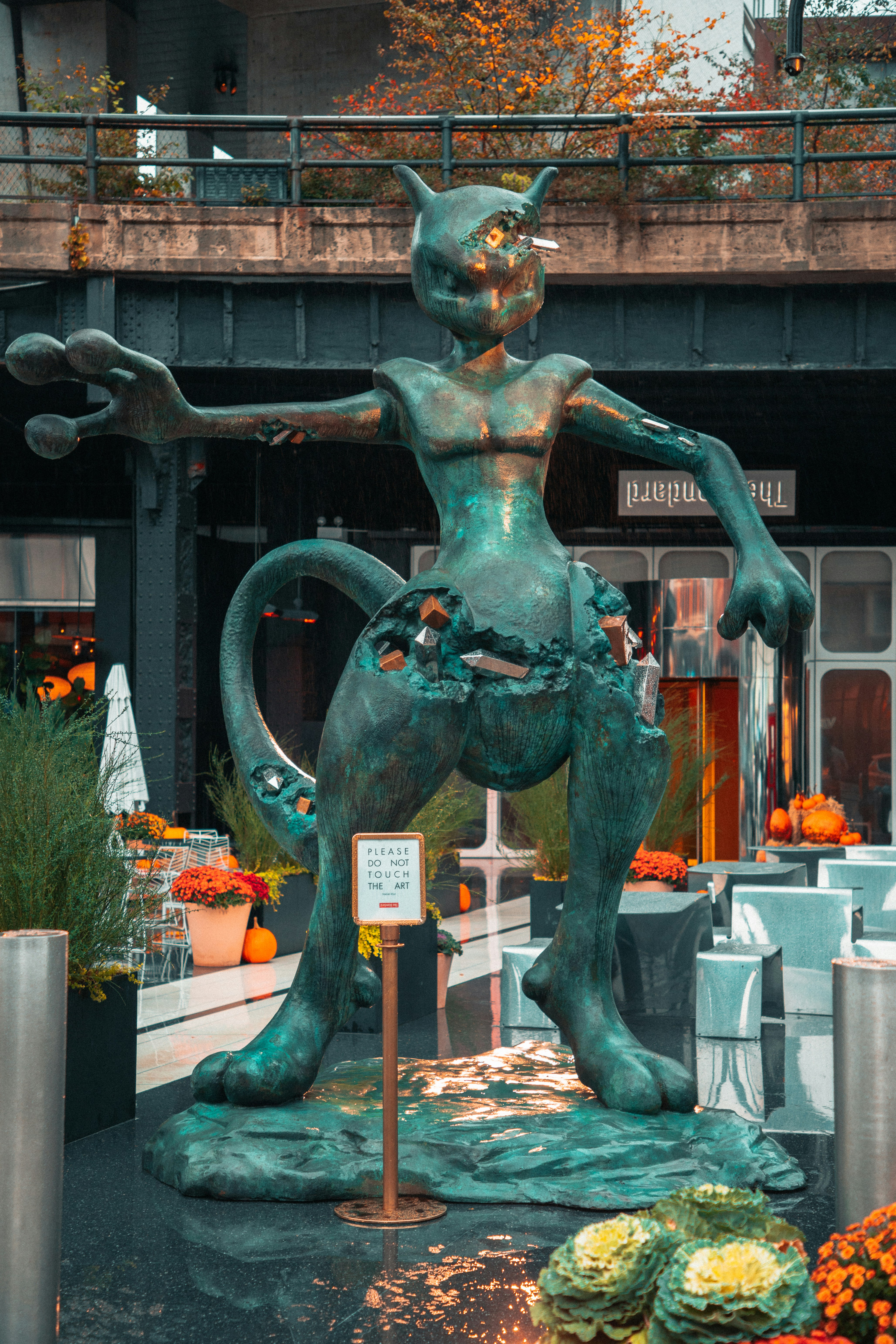 a statue of a man riding a cat in front of a building